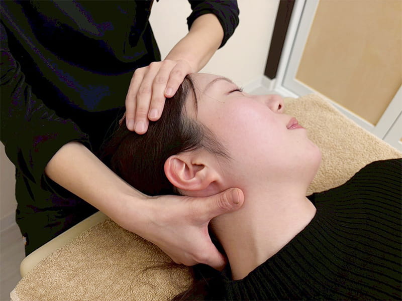 手技で小顔矯正をしている様子