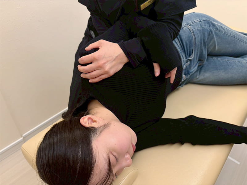 筋肉や関節を細かく優しく揺らす施術を行う様子