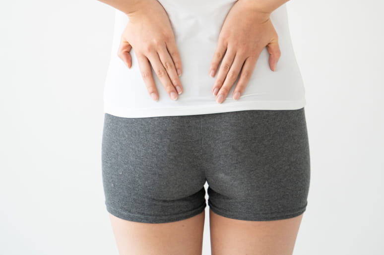 骨盤を両手で抑えている様子