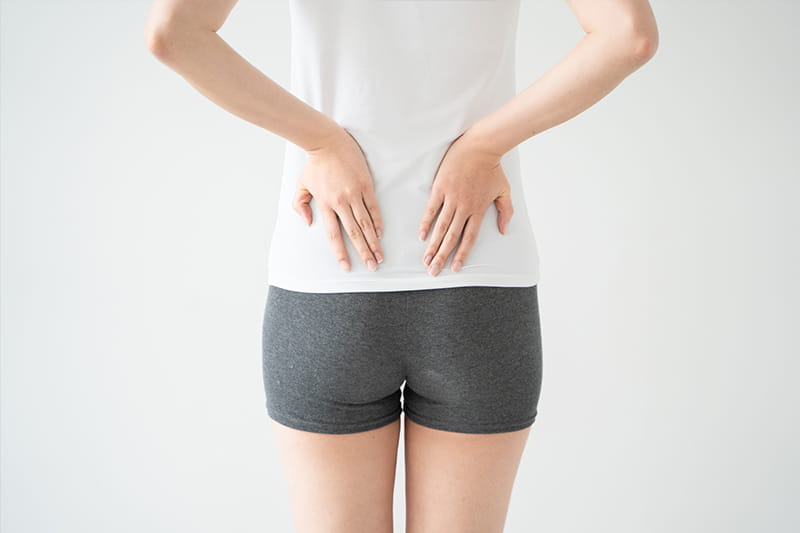 骨盤を両手で抑えている様子