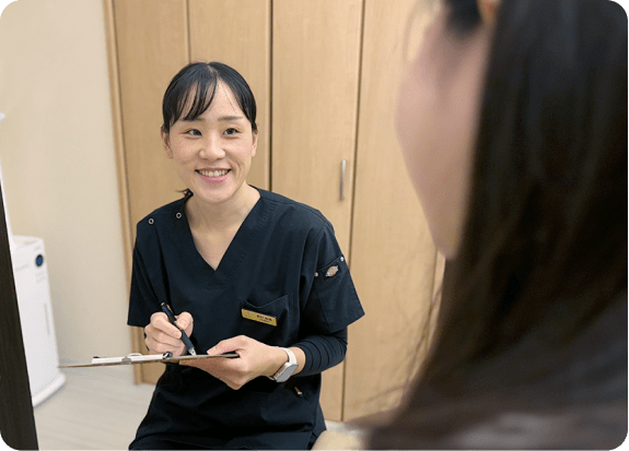 女性整体師が笑顔で問診をしている様子