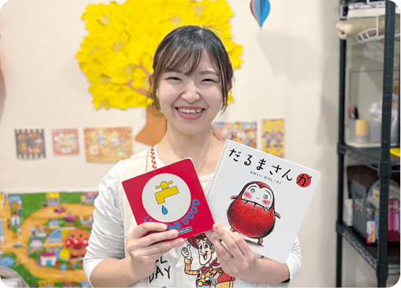 専門託児スタッフが笑顔で絵本を持っている画像