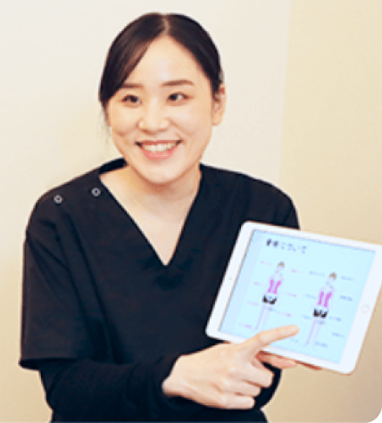 整体師が患者にタブレットを使って説明をしている場面