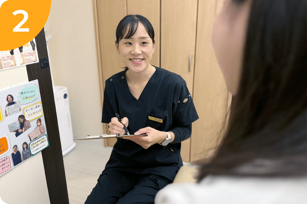 女性整体師が笑顔で問診をしている様子