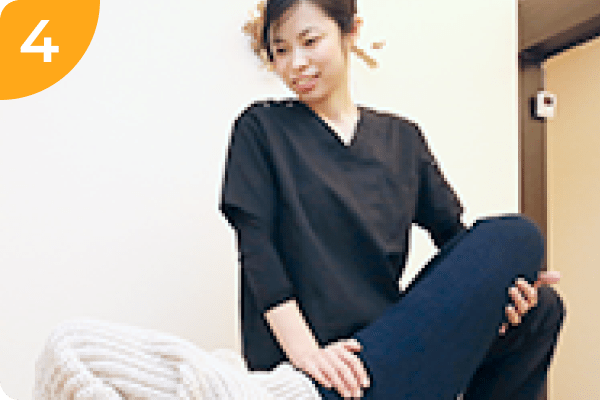 笑顔の女性整体師が患者に施術を行なっている様子