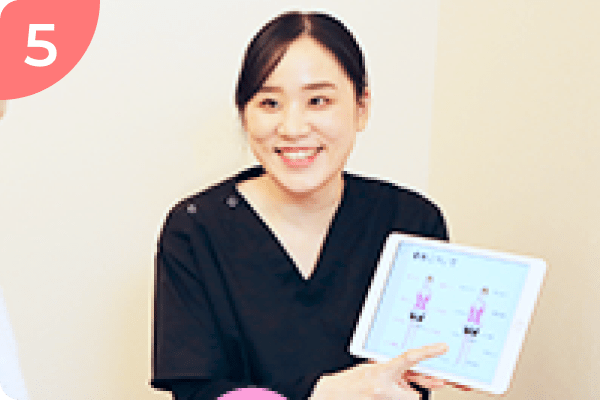 整体師が患者にタブレットを使って説明をしている場面